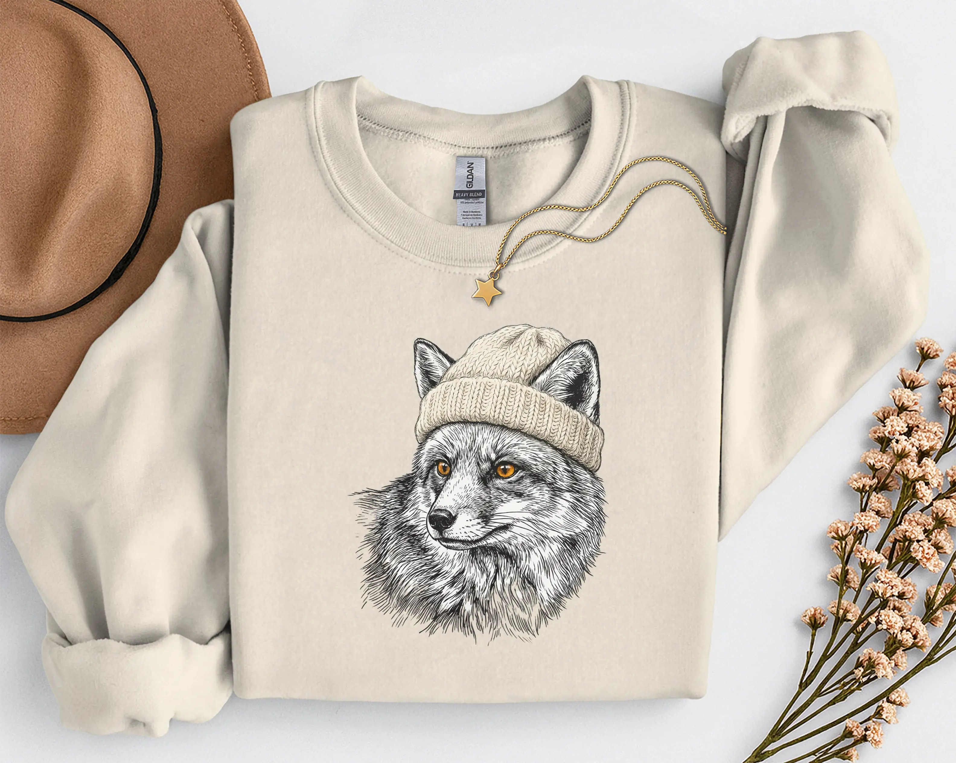 sweat-renard-bonnet-sable Sweat sable avec illustration d'un renard en bonnet, photo à plat avec chapeau et collier étoile