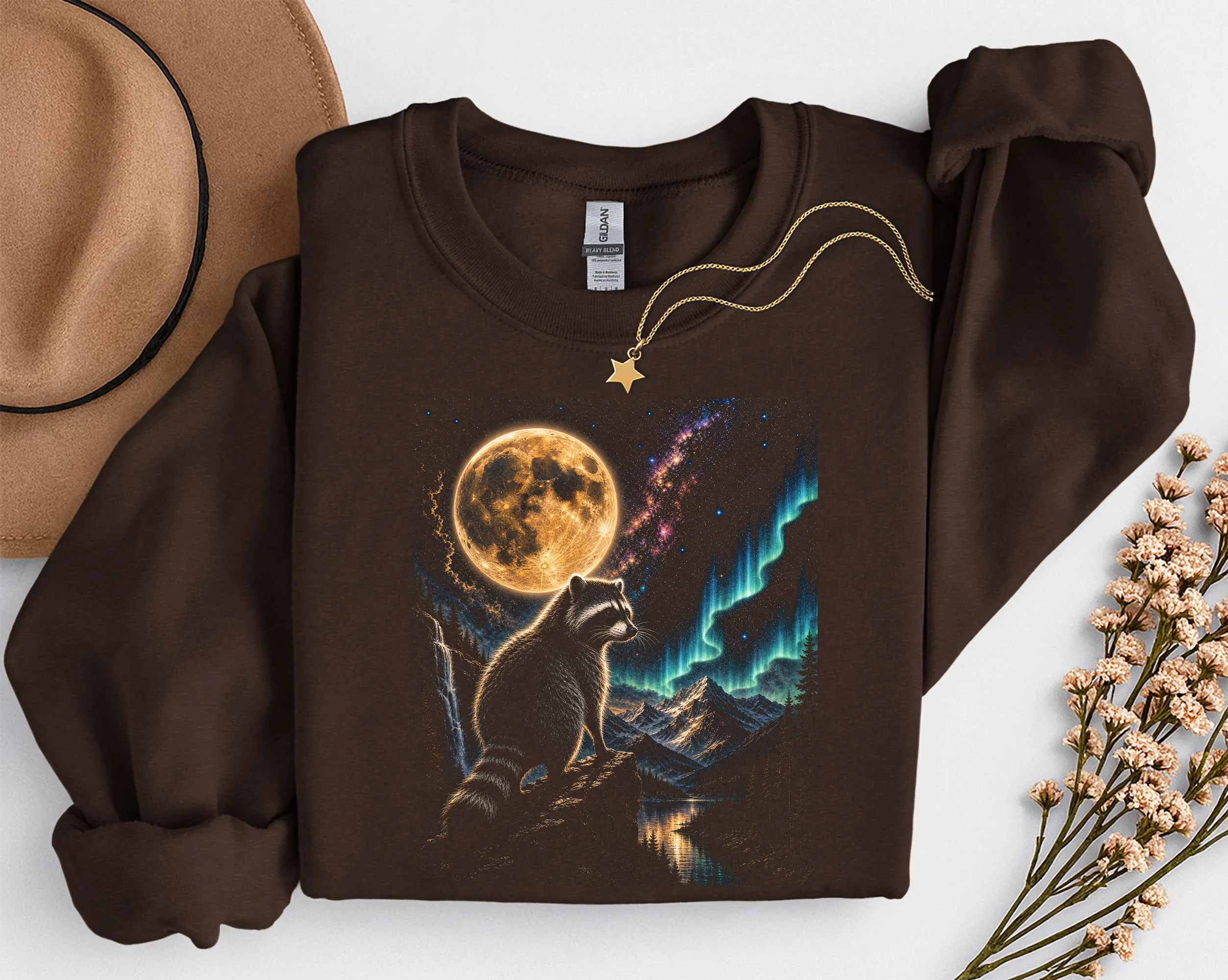 Sweat-shirt graphique marron avec le motif de raton laveur et lune plié.